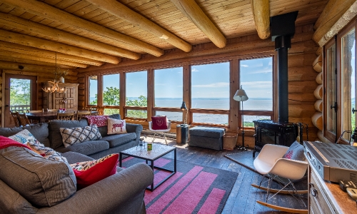 Salon avec vue plongeante sur les pentes de ski du Massif et du majesteux Fleuve st-Laurent dans Charlevoix - Chalet à louer Charlevoix