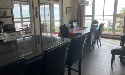 Kitchen, dining room and heated screen porch - Cottage for rent Charlevoix